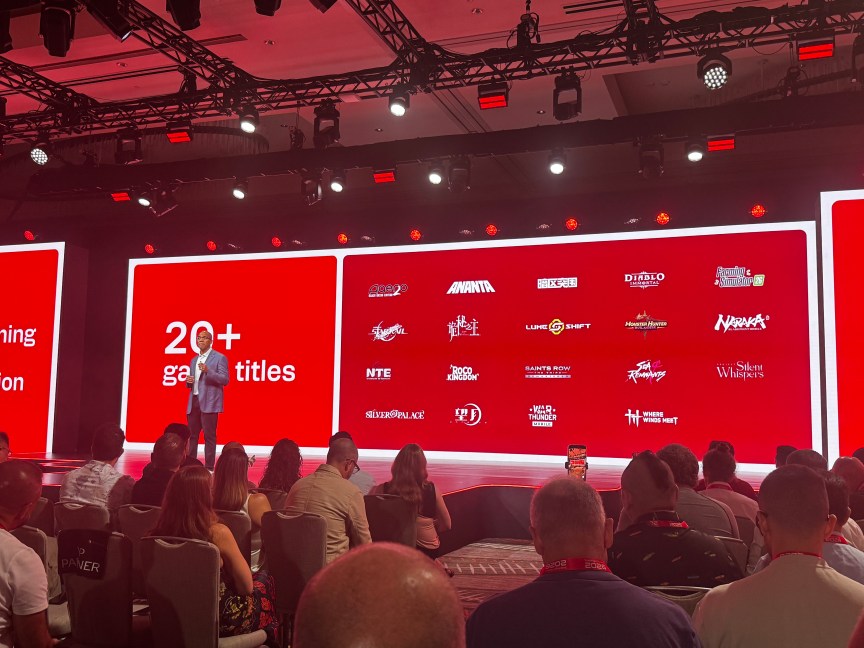 A man stands in front of a stage showing "20+ game titles" that will be updated to benefit from the new chip's advances, including Diablo Immortal, Honkai Star Rail, Where Winds Meet, Sea of Remnants, War Thunder Mobile and others.