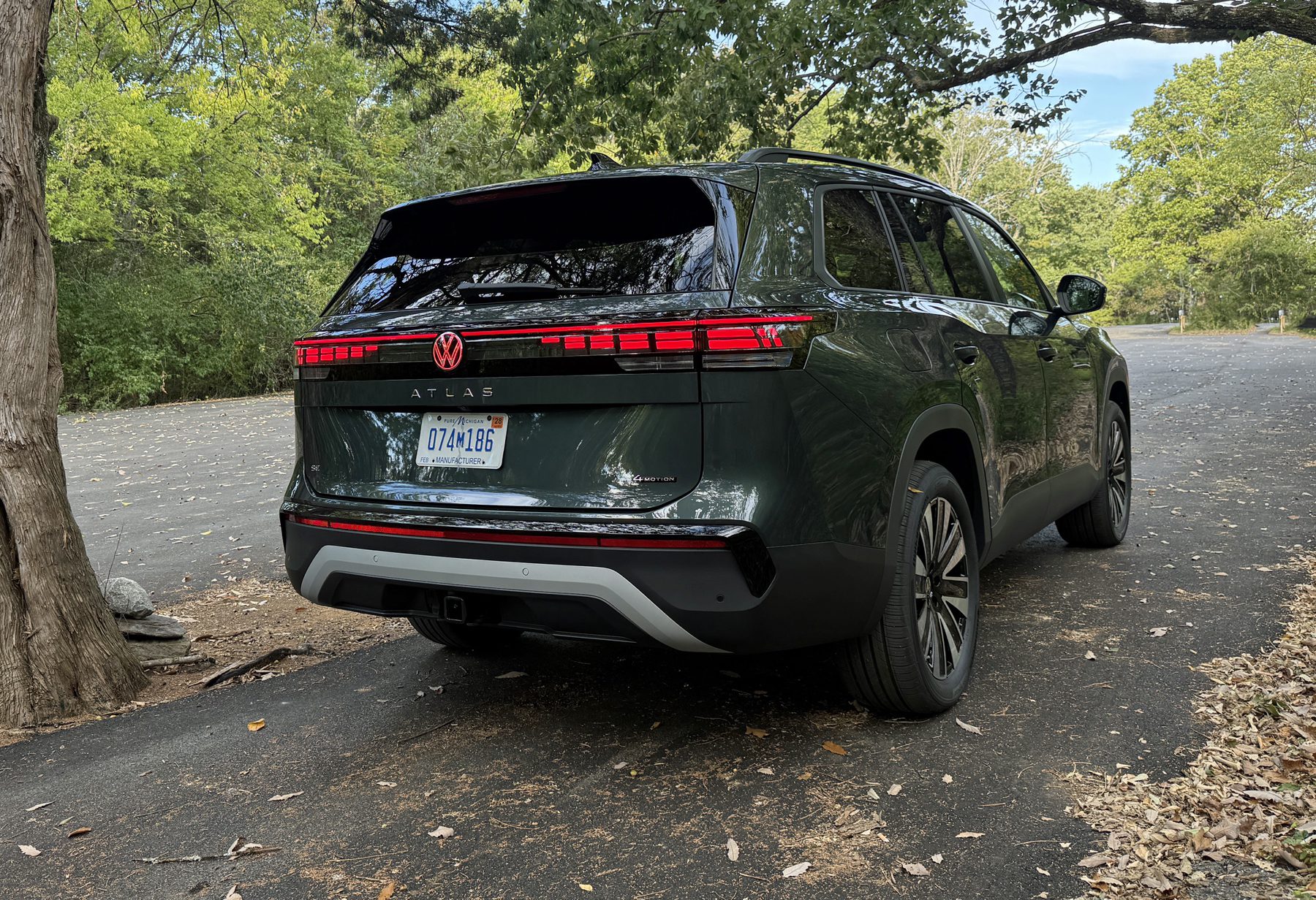 2027 Volkswagen Atlas SE, rear 3/4 view, woods,