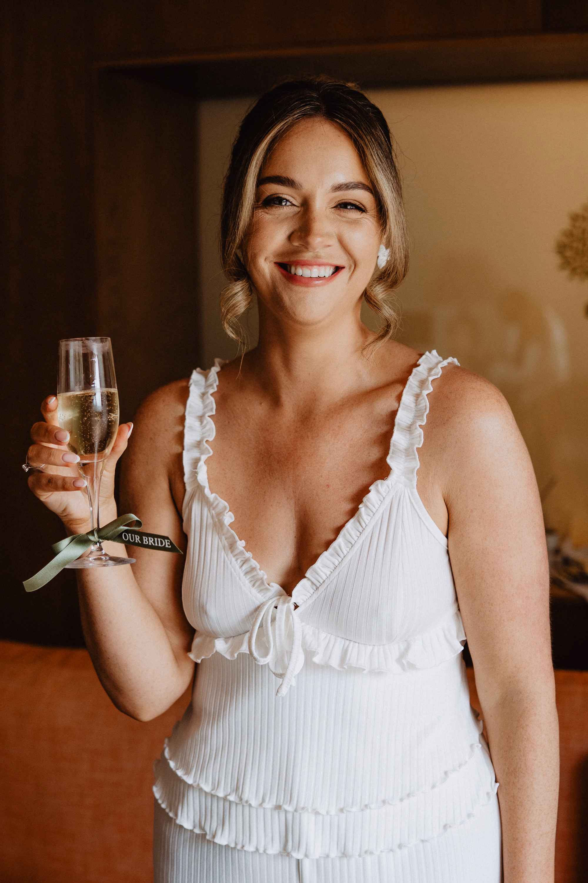 Mallorca Wedding Planner Dybiec Wedding Happiness Mode Photography 4 - How To Plan a Wedding in Mallorca From The UK, Part 2: Taking Your Wedding to Mallorca From the UK Happy bride holding a glass of champagne and smiling on her wedding day in Mallorca, planned by Dybiec Wedding