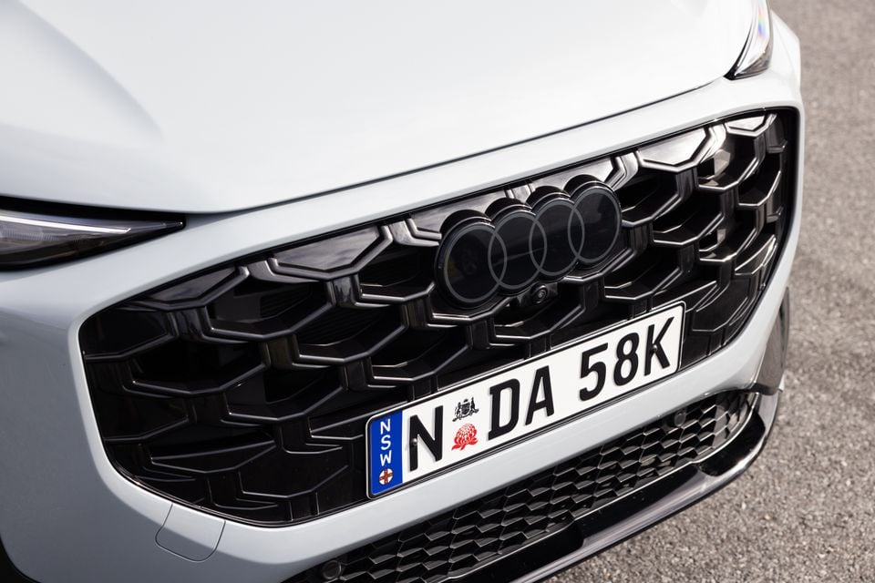 Close-up of the front grille and Audi badge on a white Audi Q3, with a NSW number plate visible