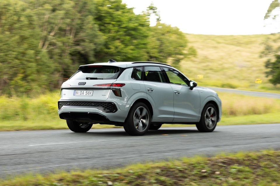 A silver Audi Q3 SUV seen from the rear three-quarter angle while driving on a rural road