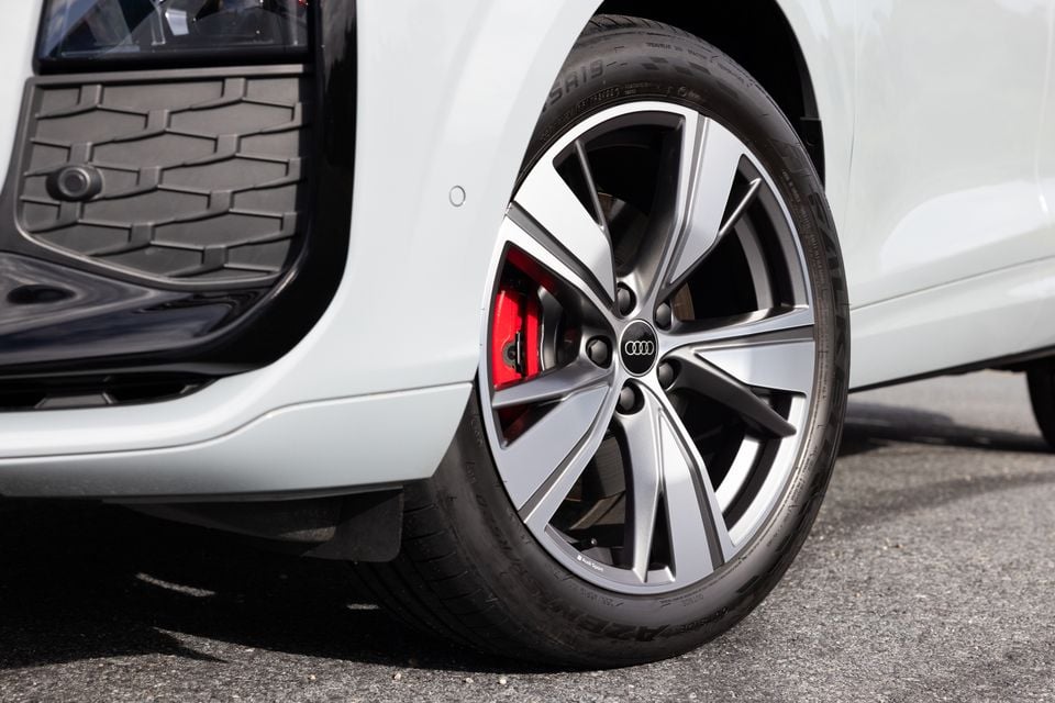 Close-up of an Audi alloy wheel with red brake callipers on a white Audi Q3 SUV
