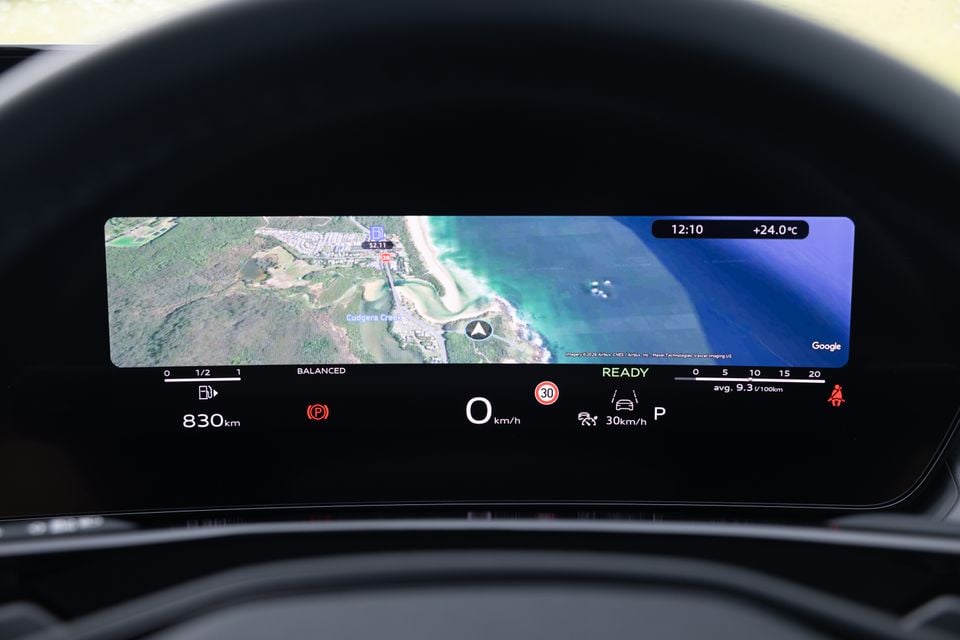 Digital instrument cluster display in an Audi Q3 showing Google Maps satellite navigation, speedometer reading 0 km/h, 830 km range, and a 30 km/h speed limit sign