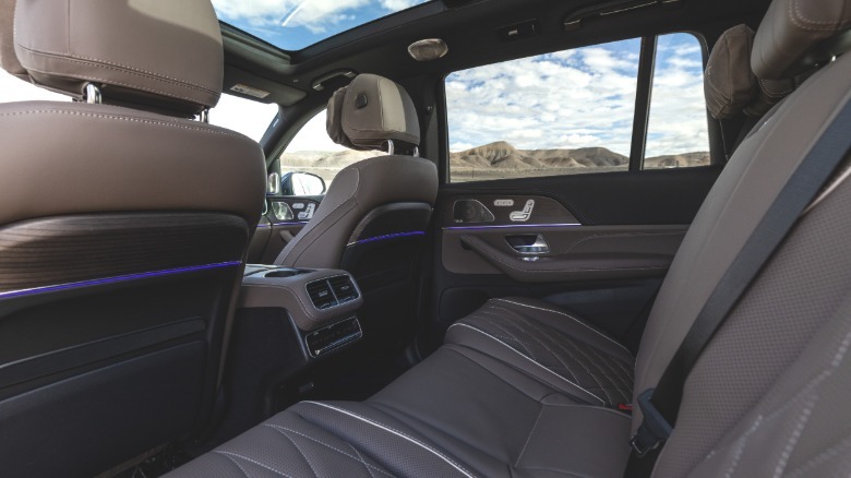 A look in the driver's side rear door of the GLS63 at the brown interior with cloudy blue skies visible out the windows and sunroof